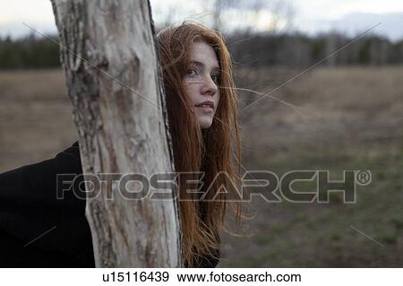 Windswept teenage girl by tree trunk View Large Photo Image Stock Photo - Windswept teenage girl by tree trunk. Fotosearch