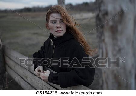 Windswept teenage girl by tree trunk View Large Photo Image Stock Photo - Windswept teenage girl by tree trunk. Fotosearch