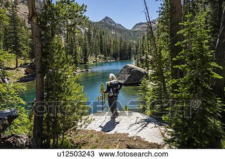 Stock Image - Woman by river in Sawtooth Mountains in Stanley, Idaho, USA. Fotosearch