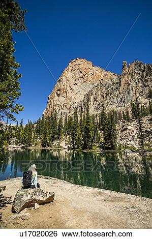 Stock Photograph - Woman by river in Sawtooth Mountains in Stanley, Idaho, USA. Fotosearch