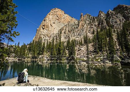 Stock Photography - Woman by river in Sawtooth Mountains in Stanley, Idaho, USA. Fotosearch