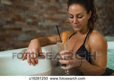 Stock Image - Woman enjoying hot tub in a spa. Fotosearch