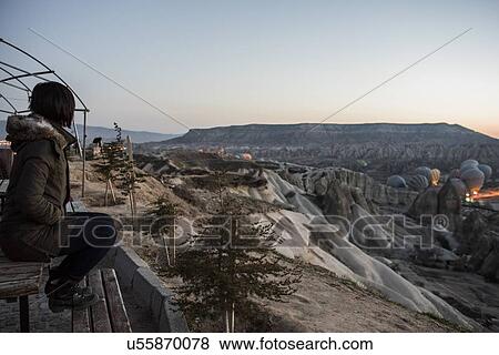 Woman enjoying view and display of hot air balloons in valley, Greme, Cappadocia, Nevsehir, Turkey View Large Photo Image Stock Photo - Woman enjoying view and display of hot air balloons in valley, Greme, Cappadocia, Nevsehir, Turkey. Fotosearch