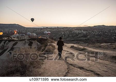 Woman enjoying view and display of hot air balloons in valley, Greme, Cappadocia, Nevsehir, Turkey View Large Photo Image Stock Photography - Woman enjoying view and display of hot air balloons in valley, Greme, Cappadocia, Nevsehir, Turkey. Fotosearch