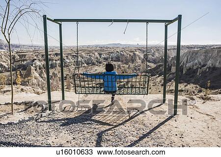 Woman enjoying view of fairy chimney valley on swing, Greme, Cappadocia, Nevsehir, Turkey View Large Photo Image Stock Image - Woman enjoying view of fairy chimney valley on swing, Greme, Cappadocia, Nevsehir, Turkey. Fotosearch