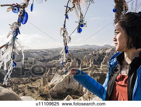 Stock Photography - Woman enjoying view of rocky valley, Greme, Cappadocia, Nevsehir, Turkey. Fotosearch