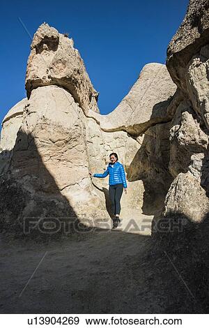 Stock Photo - Woman exploring cave, Greme, Cappadocia, Nevsehir, Turkey. Fotosearch