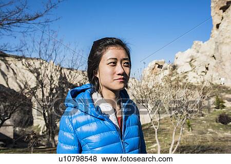 Stock Photo - Woman exploring rocky valley, Greme, Cappadocia, Nevsehir, Turkey. Fotosearch