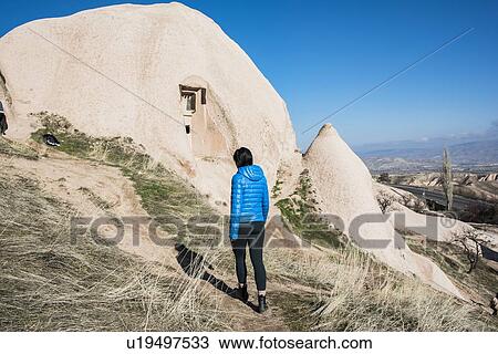 Stock Image - Woman exploring Uchisar Castle, Greme, Cappadocia, Nevsehir, Turkey. Fotosearch