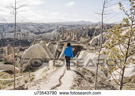 Stock Image - Woman hiking in rocky valley, Greme, Cappadocia, Nevsehir, Turkey. Fotosearch