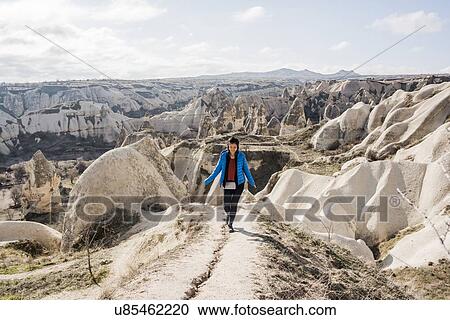 Stock Image - Woman hiking in rocky valley, Greme, Cappadocia, Nevsehir, Turkey. Fotosearch
