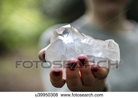 Stock Photo - Woman holding healing crystal for Reiki. Fotosearch