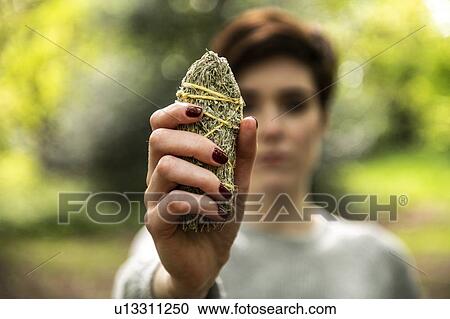Stock Image - Woman holding healing stone for Reiki. Fotosearch