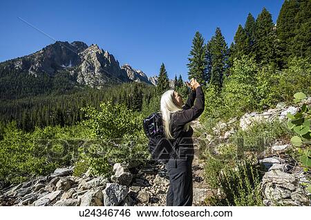 Woman photographing Sawtooth Mountains in Stanley, Idaho, USA View Large Photo Image Stock Photograph - Woman photographing Sawtooth Mountains in Stanley, Idaho, USA. Fotosearch