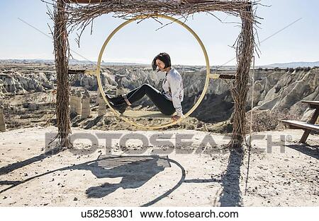 Woman playing on circular swing overlooking fairy chimney valley, Greme, Cappadocia, Nevsehir, Turkey View Large Photo Image Stock Image - Woman playing on circular swing overlooking fairy chimney valley, Greme, Cappadocia, Nevsehir, Turkey. Fotosearch