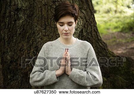 Woman practising Reiki, large tree trunk in background View Large Photo Image Stock Image - Woman practising Reiki, large tree trunk in background. Fotosearch