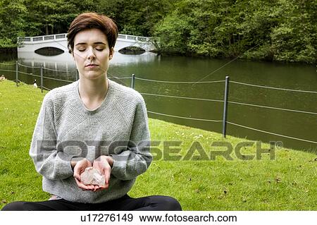 Woman practising Reiki on grass lawn by river, London, UK View Large Photo Image Stock Photo - Woman practising Reiki on grass lawn by river, London, UK. Fotosearch