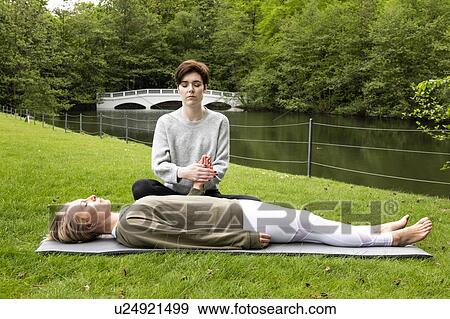 Woman practising Reiki on grass lawn by river, London, UK View Large Photo Image Stock Photo - Woman practising Reiki on grass lawn by river, London, UK. Fotosearch