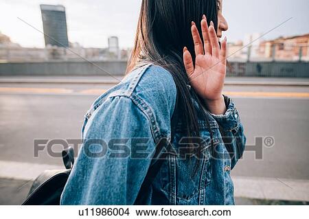 Picture - Woman shying away from being photograph, Milan, Italy. Fotosearch