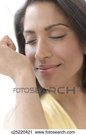 Stock Image - Woman smelling perfume on wrist. Fotosearch