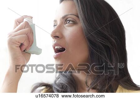 Woman using asthma inhaler View Large Photo Image Stock Photo - Woman using asthma inhaler. Fotosearch