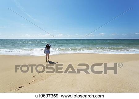 Woman walking on beach in Lisbon, Portugal View Large Photo Image Stock Photo - Woman walking on beach in Lisbon, Portugal. Fotosearch