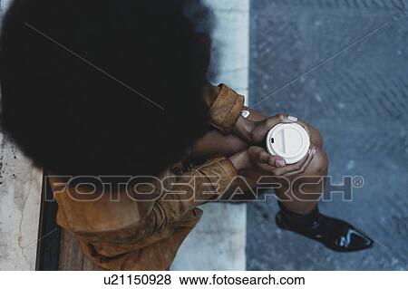 Woman with afro hair clasping hot drink View Large Photo Image Stock Photo - Woman with afro hair clasping hot drink. Fotosearch