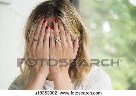 Woman with her hands covering her face View Large Photo Image Stock Image - Woman with her hands covering her face. Fotosearch
