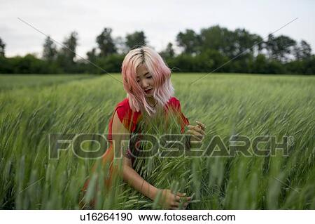 Woman with pink hair wearing red dress in wheat field View Large Photo Image Stock Image - Woman with pink hair wearing red dress in wheat field. Fotosearch