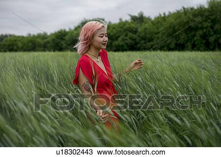 Woman with pink hair wearing red dress in wheat field View Large Photo Image Stock Image - Woman with pink hair wearing red dress in wheat field. Fotosearch