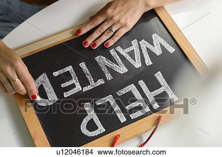 Woman writing 'Help Wanted' on chalkboard View Large Photo Image Picture - Woman writing 'Help Wanted' on chalkboard. Fotosearch