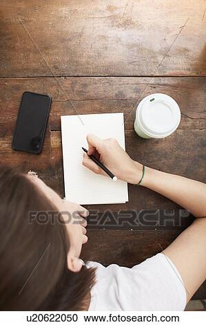 Woman writing on notebook at coffee break View Large Photo Image Stock Image - Woman writing on notebook at coffee break. Fotosearch