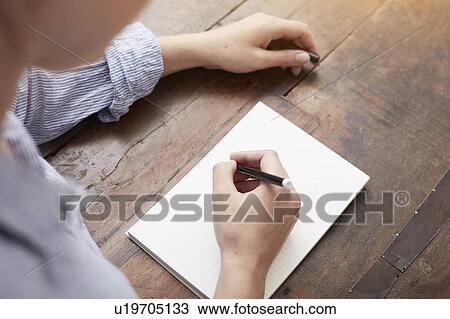 Stock Image - Woman writing on notebook. Fotosearch