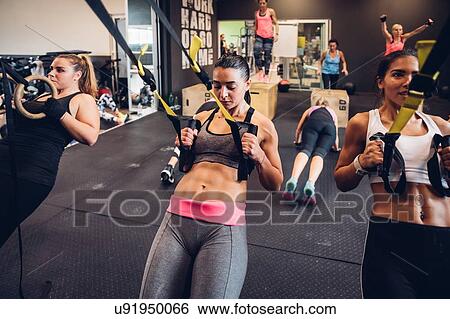 Stock Photograph - Women training in gym, resistance training. Fotosearch