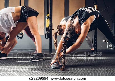 Women training in gym, touching toes View Large Photo Image Picture - Women training in gym, touching toes. Fotosearch
