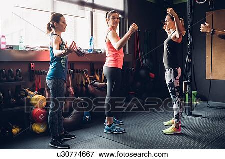 Women training in gym with arms raised View Large Photo Image Stock Photo - Women training in gym with arms raised. Fotosearch