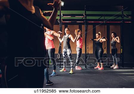 Stock Photography - Women training in gym, with arms raised. Fotosearch