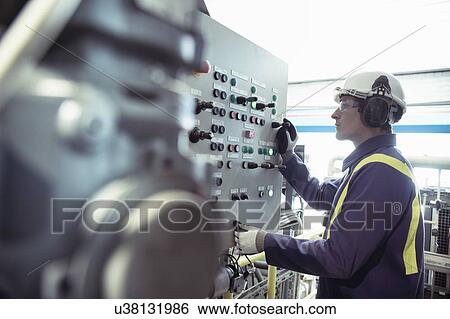 Stock Photograph - Worker at controls of furnace in titanium recycling plant. Fotosearch