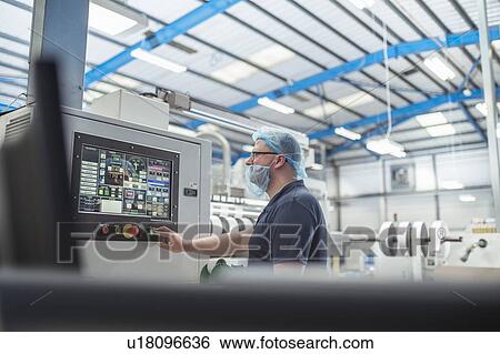 Stock Photograph - Worker controlling printer in print factory. Fotosearch