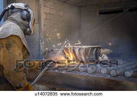 Stock Photography - Worker cutting up scrap titanium aircraft parts in titanium recycling plant. Fotosearch