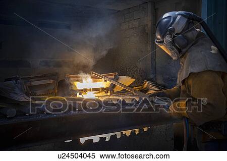 Stock Photography - Worker cutting up scrap titanium aircraft parts in titanium recycling plant. Fotosearch