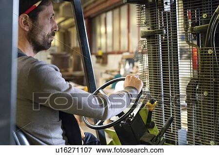 Worker driving forklift in factory View Large Photo Image Stock Photo - Worker driving forklift in factory. Fotosearch