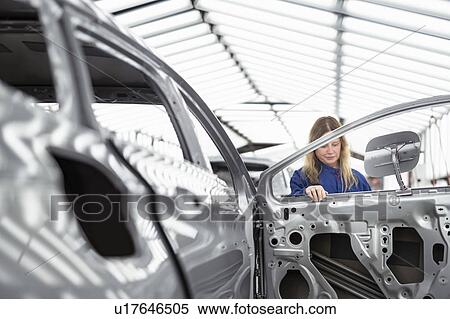 Worker inspecting car body in paint inspection area in car factory View Large Photo Image Stock Photography - Worker inspecting car body in paint inspection area in car factory. Fotosearch