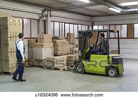 Worker lifting pallet of boxes with forklift in factory View Large Photo Image Stock Photograph - Worker lifting pallet of boxes with forklift in factory. Fotosearch