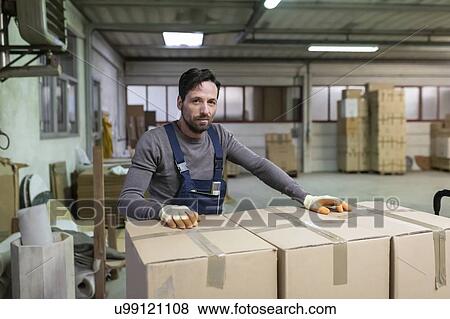 Worker resting hands on boxes in factory View Large Photo Image Stock Photo - Worker resting hands on boxes in factory. Fotosearch