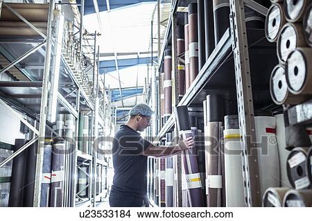 Worker selecting print rolls in print factory View Large Photo Image Picture - Worker selecting print rolls in print factory. Fotosearch