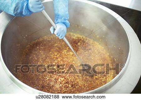 Worker stirring batch of food in food factory, close up View Large Photo Image Stock Photo - Worker stirring batch of food in food factory, close up. Fotosearch
