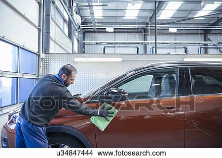 Worker valeting car in car dealership View Large Photo Image Picture - Worker valeting car in car dealership. Fotosearch