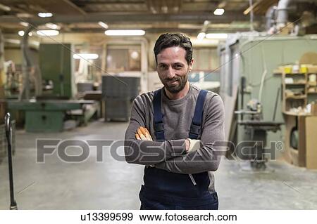 Stock Photo - Worker with arms crossed in factory. Fotosearch