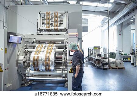 Stock Photography - Worker with food packaging printing machine in print factory. Fotosearch